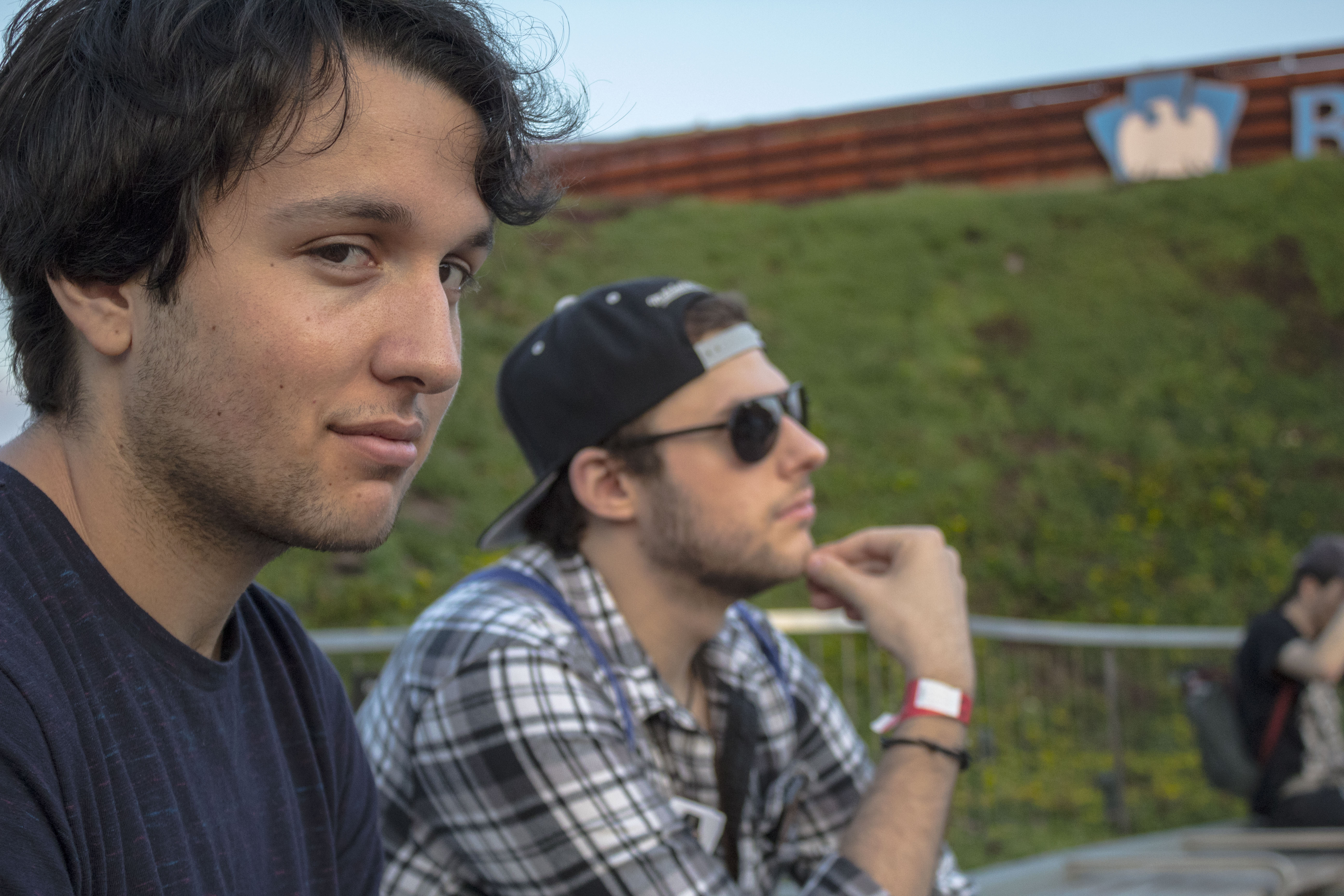 man looking shiftily into camera with another man looking pensive